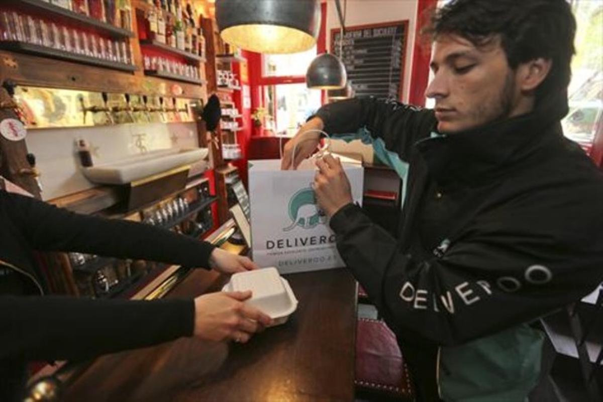 Un repartidor de Deliveroo recoge un pedido en La Taverna del Suculent.