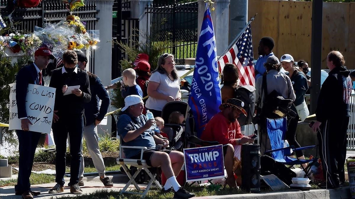 Varios de los seguidores de Trump que montan guardia a las puertas del hospital, este lunes. Varios de los seguidores de Trump que montan guardia a las puertas del hospital, este lunes.