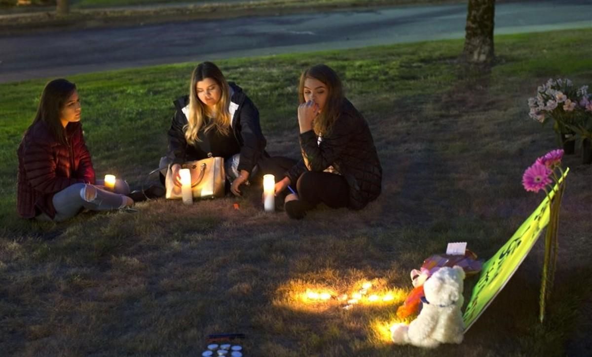 Unas jóvenes encienden velas en memoria de las víctimas del tiroteo en Burlington. Unas jóvenes encienden velas en memoria de las víctimas del tiroteo en Burlington.