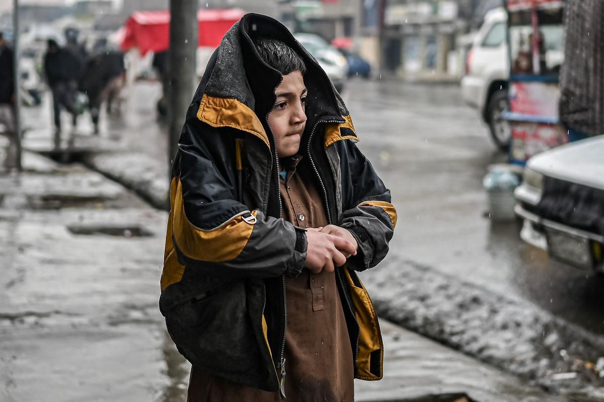 Un niño afgano se protege del frío mientras camina por una calle de Kabul, el pasado 1 de enero.
