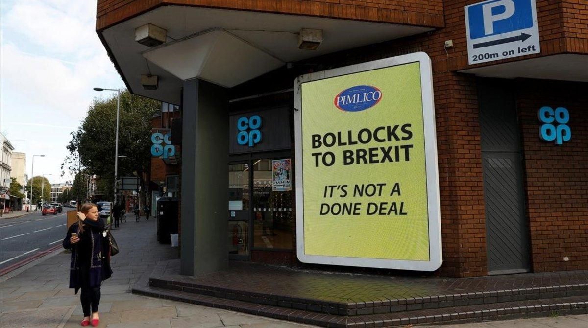 Una mujer pasa al lado de uno de los carteles anti-Brexit en Londres Una mujer pasa al lado de uno de los carteles anti-Brexit en Londres