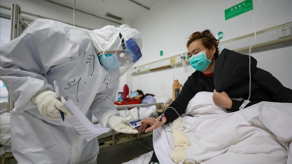 Un médico examina a un paciente con coronavirus en el hospital de Wuhan, este jueves. Un médico examina a un paciente con coronavirus en el hospital de Wuhan, este jueves.