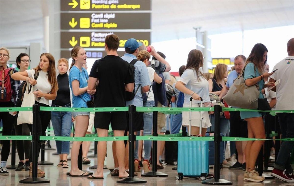 Pasajeros esperan para pasar los controles de seguridad en el aeropuerto de El Prat. Pasajeros esperan para pasar los controles de seguridad en el aeropuerto de El Prat.