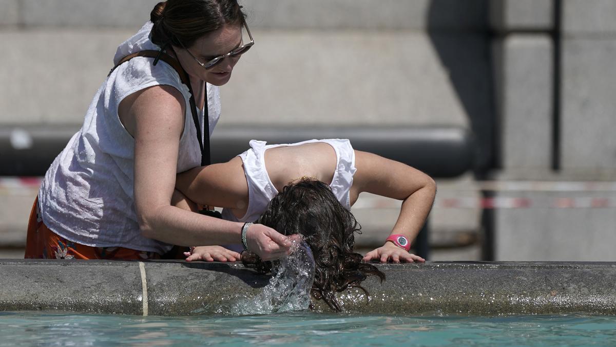 Una mujer se refresca en la fuente de Trafalgar Square, en Londres.
