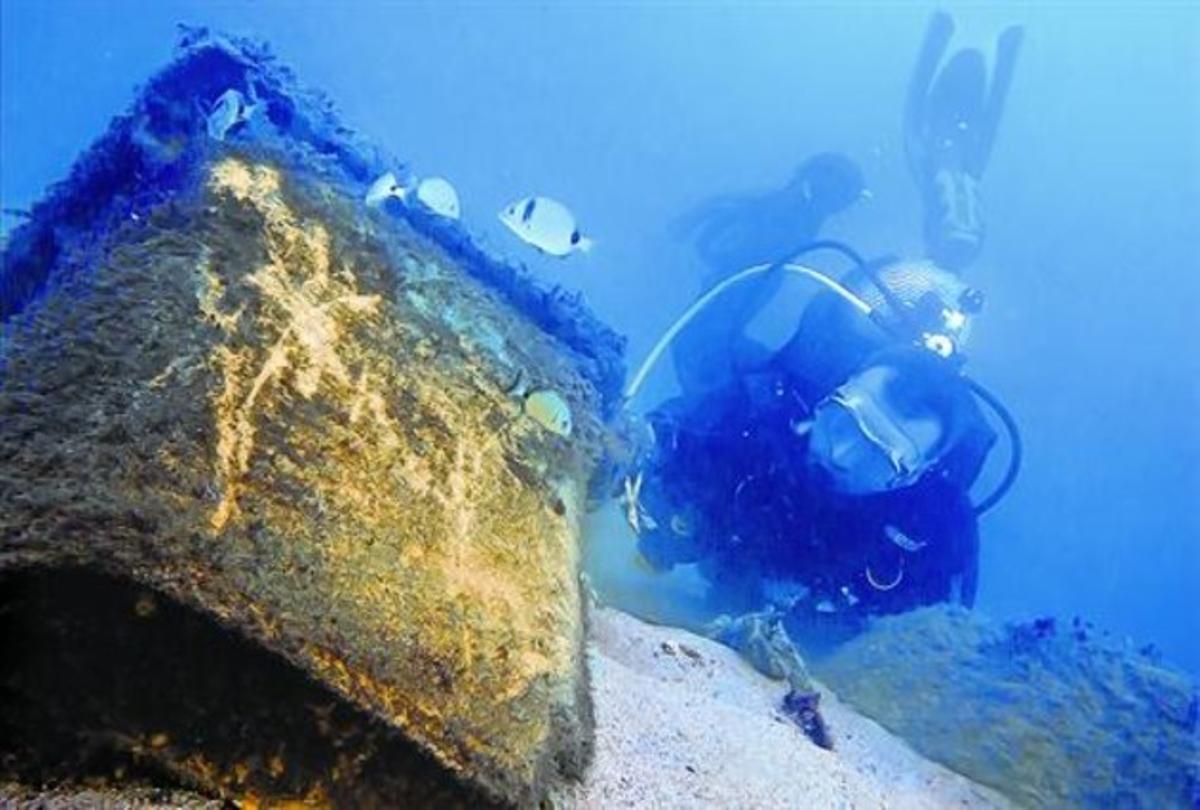 Un submarinista retira un contenedor de basuras hundido junto al espigón de la Mar Bella, en Barcelona, en noviembre del 2011.