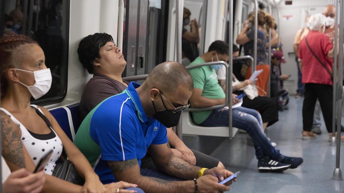 Pasajeros con y sin mascarilla en el interior de un vagón de metro en Barcelona.