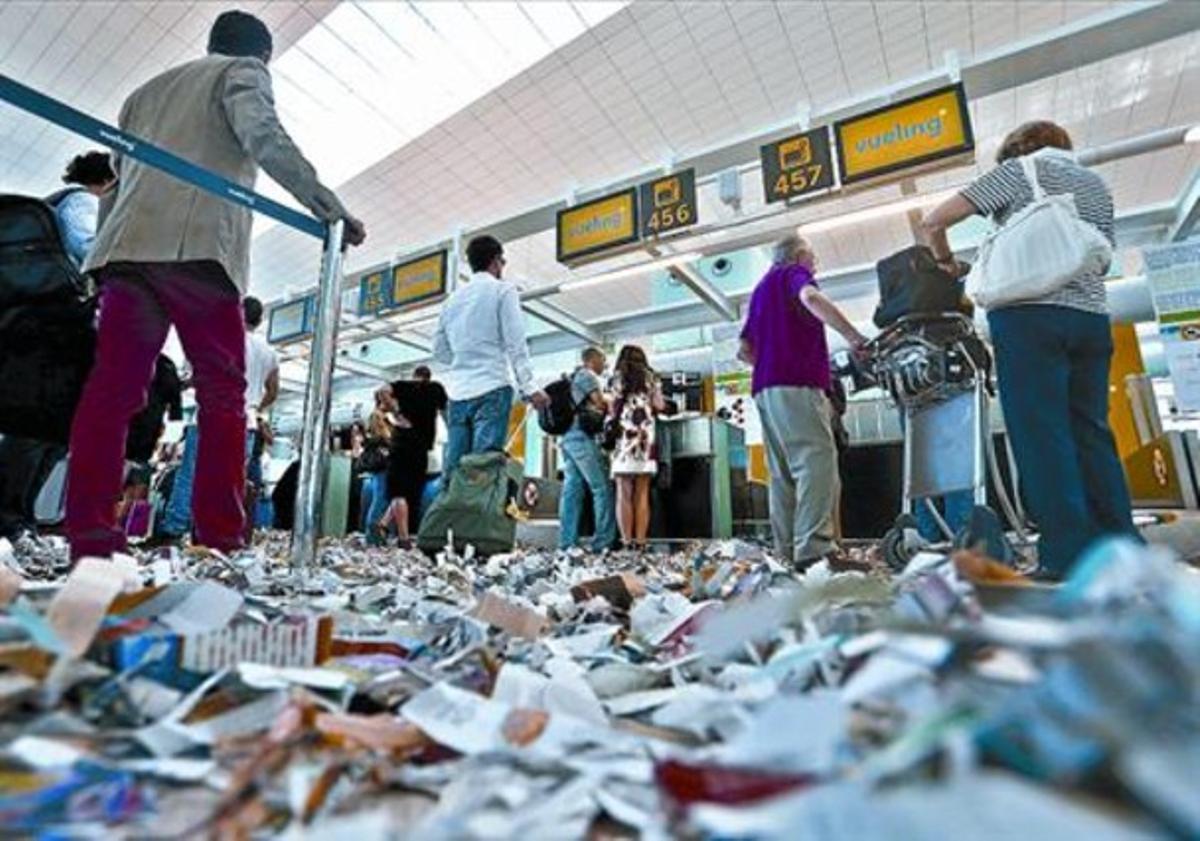 Recortes de periódico tirados por los trabajadores de la limpieza en huelga alfombran el suelo de la T-1, ayer.