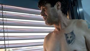 Antonio García mira a través de la ventana de su nuevo piso, con el tatuaje de su perro ’Blanco’.