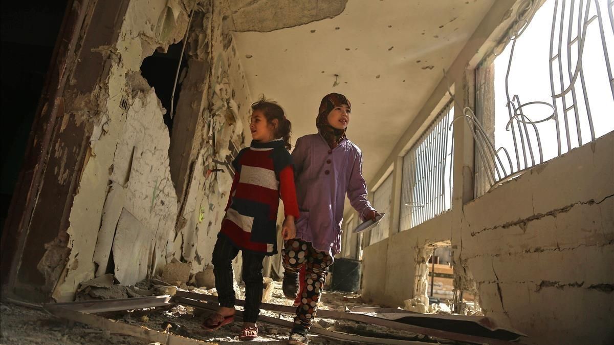 Dos niñas sirias recorren su escuela, destrozada el día anterior por los ataques áereos de la aviación gubernamental, en la sitiada ciudad de Saqba (Guta Oriental), el 9 de noviembre. Dos niñas sirias recorren su escuela, destrozada el día anterior por los ataques áereos de la aviación gubernamental, en la sitiada ciudad de Saqba (Guta Oriental), el 9 de noviembre.