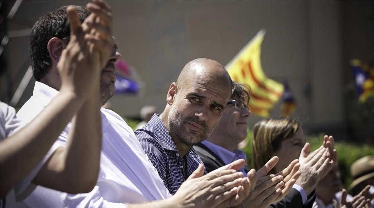 Pep Guardiola, entre Carles Puigdemont y Oriol Junqueras, este domingo, en la manifestación de la ANC, Òmnium y la AMI. Pep Guardiola, entre Carles Puigdemont y Oriol Junqueras, este domingo, en la manifestación de la ANC, Òmnium y la AMI.