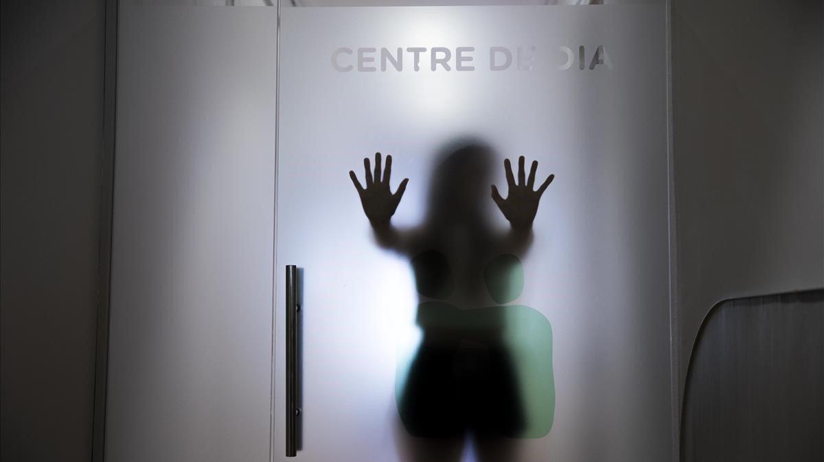 Una paciente de anorexia se apoya contra una puerta de cristal en un servicio especializado.