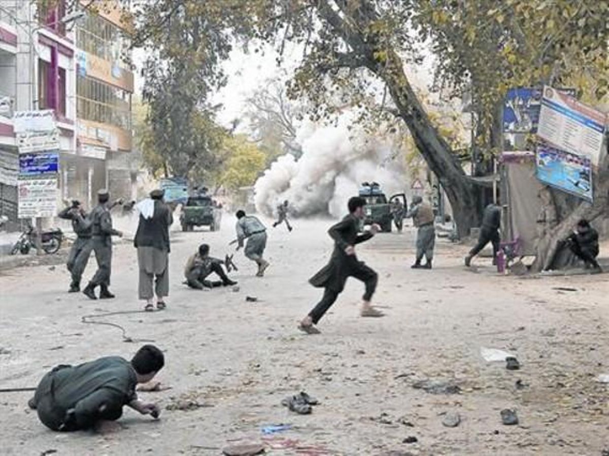 Civiles y militares afganos corren tras el atentado suicida cometido en Jalalabad, este sábado. Civiles y militares afganos corren tras el atentado suicida cometido en Jalalabad, este sábado.