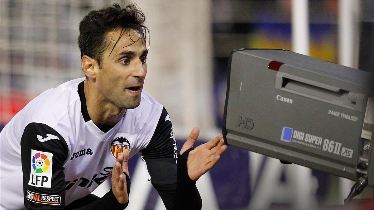 El jugador del Valencia Jonás celebra un gol en Mestalla  ante una cámara de televisión. 