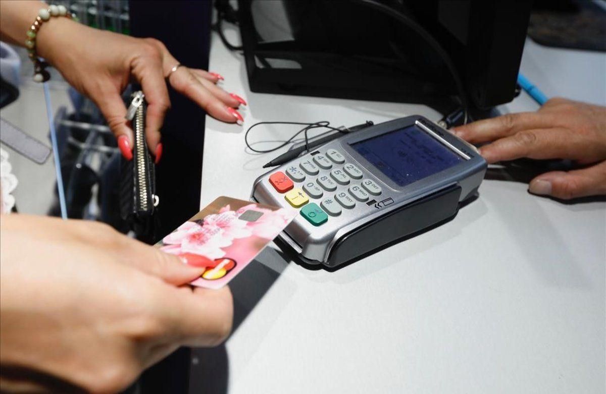 Cliente realizando un pago con un tarjeta en un comercio. Cliente realizando un pago con un tarjeta en un comercio.