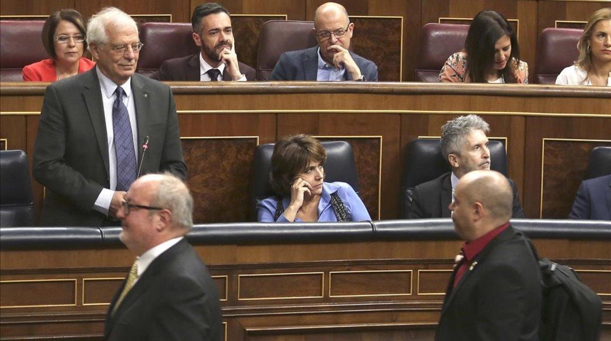 El diputado Jordi Salvador (ERC), con la camisa roja, pasa por delante del ministro Josep Borrell, que le acusó de haberle escupido.