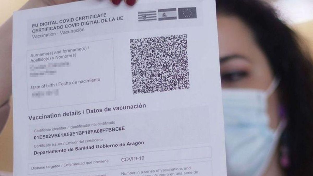 Una mujer enseña su pasaporte covid. Una mujer enseña su pasaporte covid.