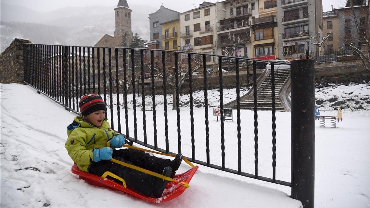 Un niño juega con un trineo en la nieve fruto de la borrasca Filomena en Sort Lleida Un niño juega con un trineo en la nieve fruto de la borrasca Filomena en Sort Lleida