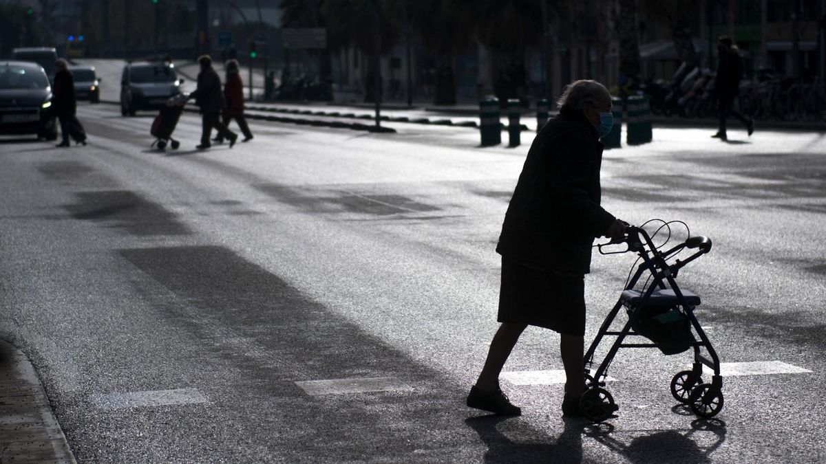 Una señora mayor cruza apoyada en su caminador la calle Marina de Barcelona. Una señora mayor cruza apoyada en su caminador la calle Marina de Barcelona.