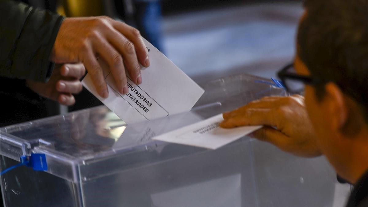 Un ciudadano deposita su voto en una urna. 