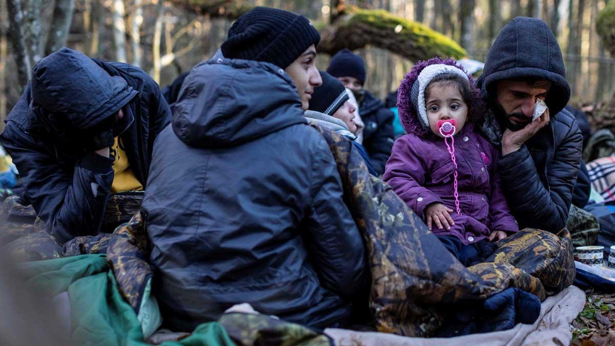 Cientos de migrantes intentan cruzar la frontera entre Polonia y Bielorrusia de noche. En la foto, una familia kurda procedente de la ciudad iraquí de Duhok espera cerca de Narewka (Polonia).