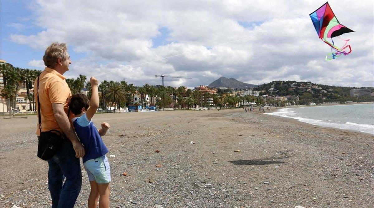 Un niño vuela una cometa junto a su padre en la playa en el primer día en el que los menores de 14 años pueden salir durante el estado de alarma. Un niño vuela una cometa junto a su padre en la playa en el primer día en el que los menores de 14 años pueden salir durante el estado de alarma.