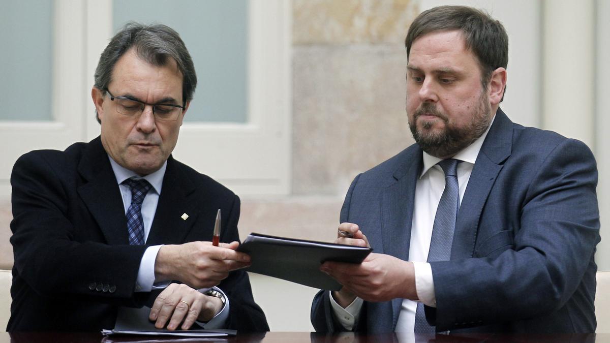 CiU leader Artur Mas and ERC leader Junqueras exchange documents of an agreed alliance at Parliament de Catalunya in Barcelona