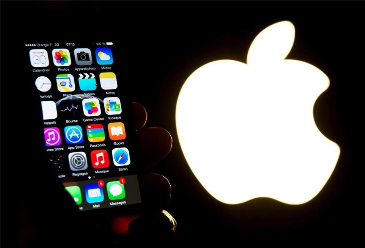 Un iPhone junto al logo de Apple.
