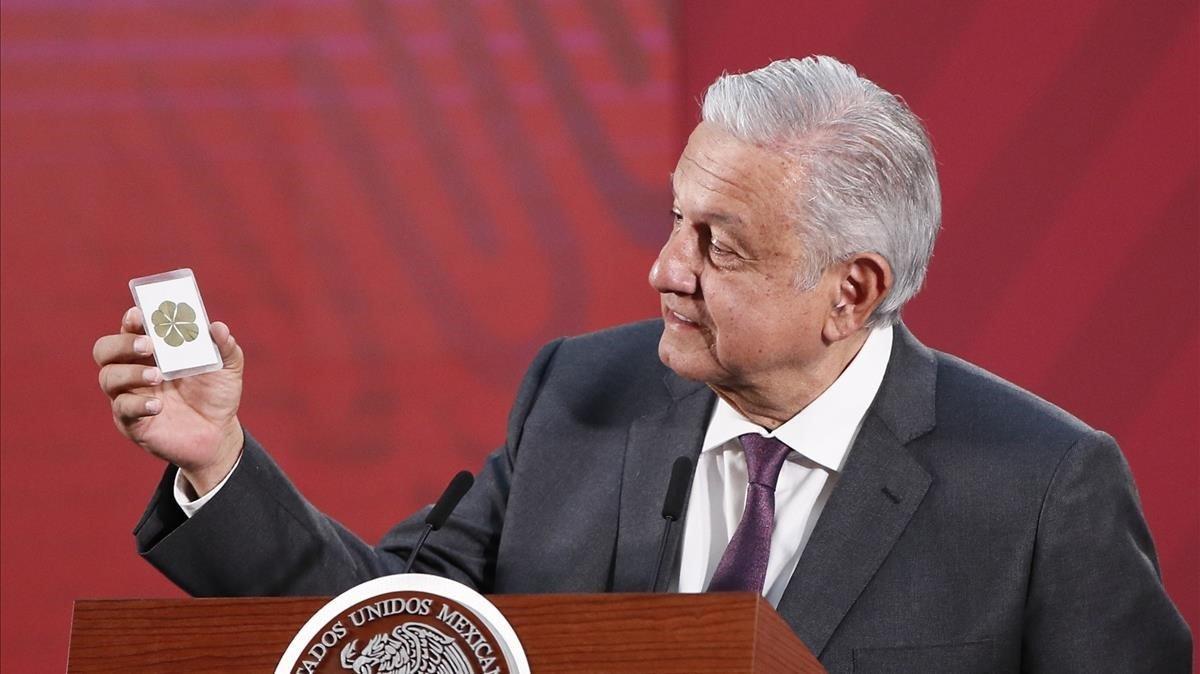 El presidente de México, Andrés Manuel López Obrador, muestra una estampa con un trébol de seis hojas durante una rueda de prensa el pasado 19 de marzo.