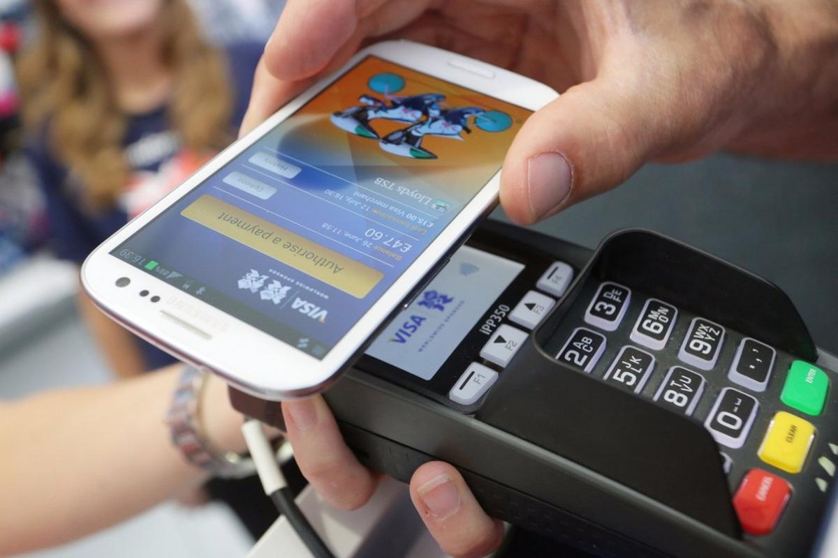 Un usuario paga una compra con el móvil a través del TPV.