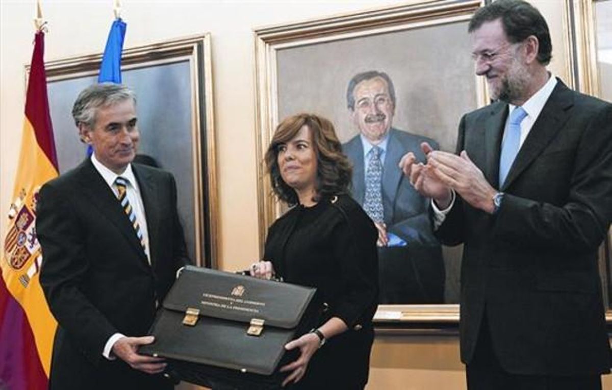 Sáenz de Santamaría recibe la cartera de manos de Jáuregui, en presencia de Rajoy, ayer. Sáenz de Santamaría recibe la cartera de manos de Jáuregui, en presencia de Rajoy, ayer.