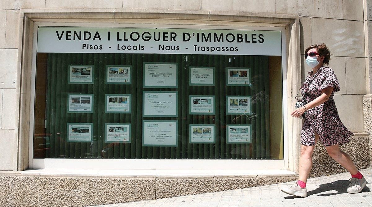 Una mujer pasa por delante del escaparate de una inmobiliaria de Barcelona, el pasado 1 de julio. Una mujer pasa por delante del escaparate de una inmobiliaria de Barcelona, el pasado 1 de julio.