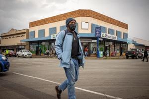 Un hombre con mascarilla pasea por una calle de Johannesburgo.