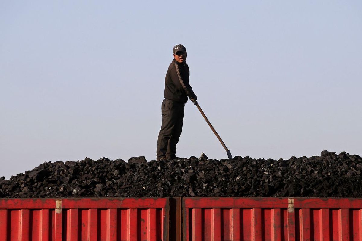 Un trabajador sobe el cargamento de carbón que transporta un tren, en el centro de China. Un trabajador sobe el cargamento de carbón que transporta un tren, en el centro de China.