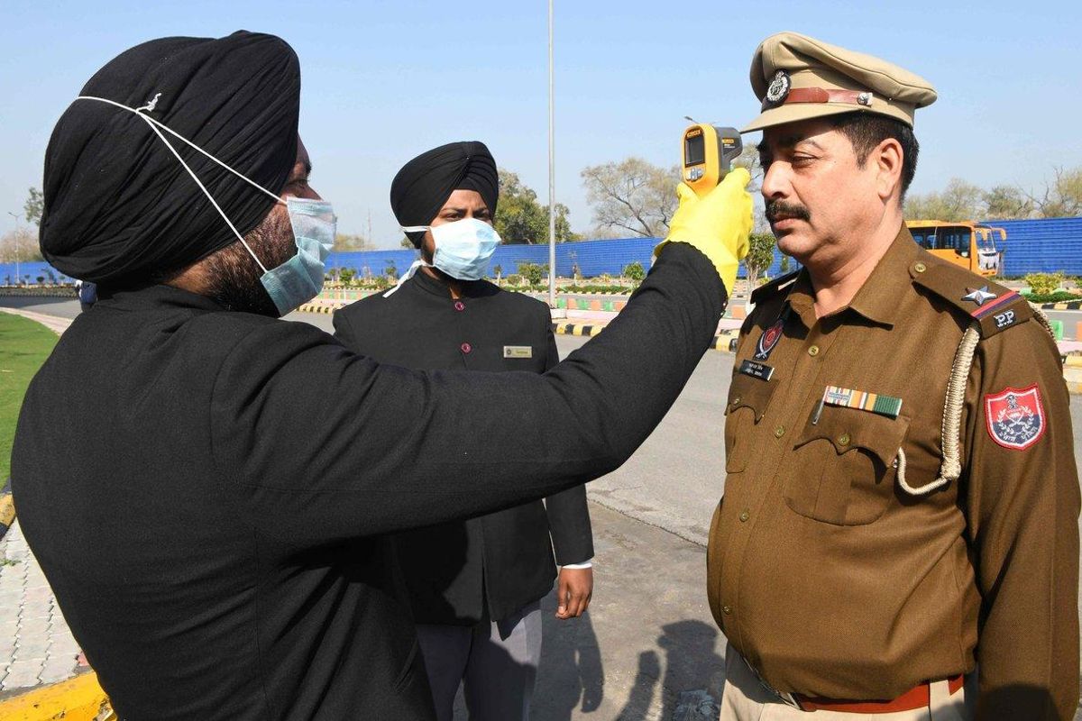 Miembros del personal de un hotel de Amritsar (India) toman la temperatura de un personal de la policía en la entrada del establecimiento, este domingo, para detectar si tiene coronavirus. Miembros del personal de un hotel de Amritsar (India) toman la temperatura de un personal de la policía en la entrada del establecimiento, este domingo, para detectar si tiene coronavirus.