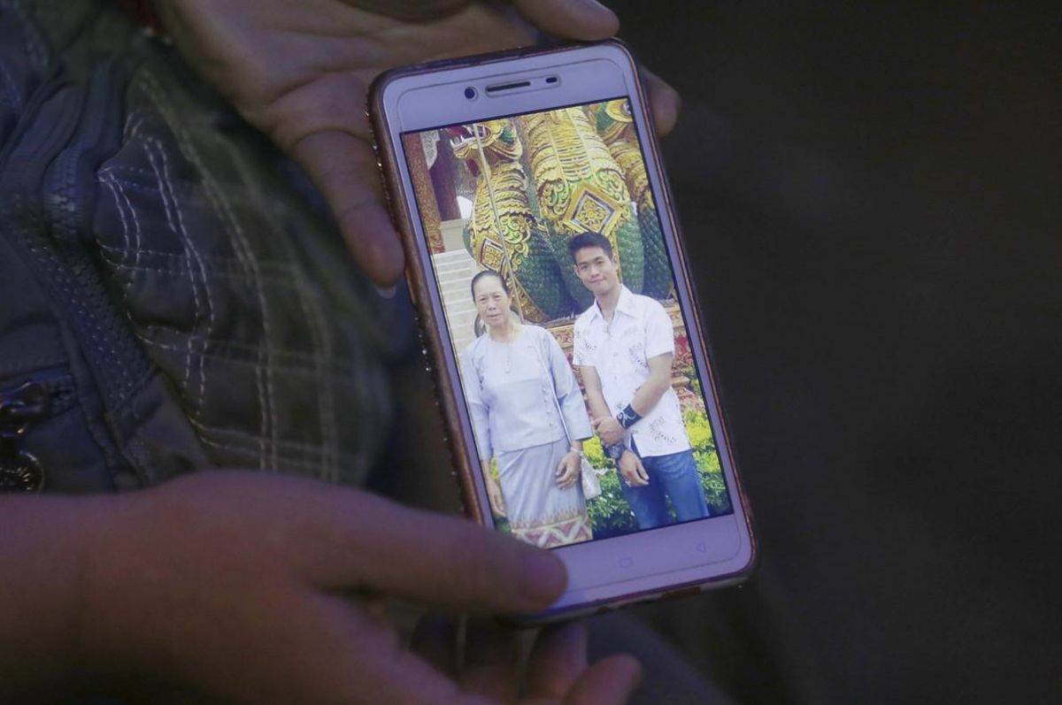 La tia del entrenador Ekapol Chantawong muestra una foto de móvil en la que aparece él y su abuela. La tia del entrenador Ekapol Chantawong muestra una foto de móvil en la que aparece él y su abuela.