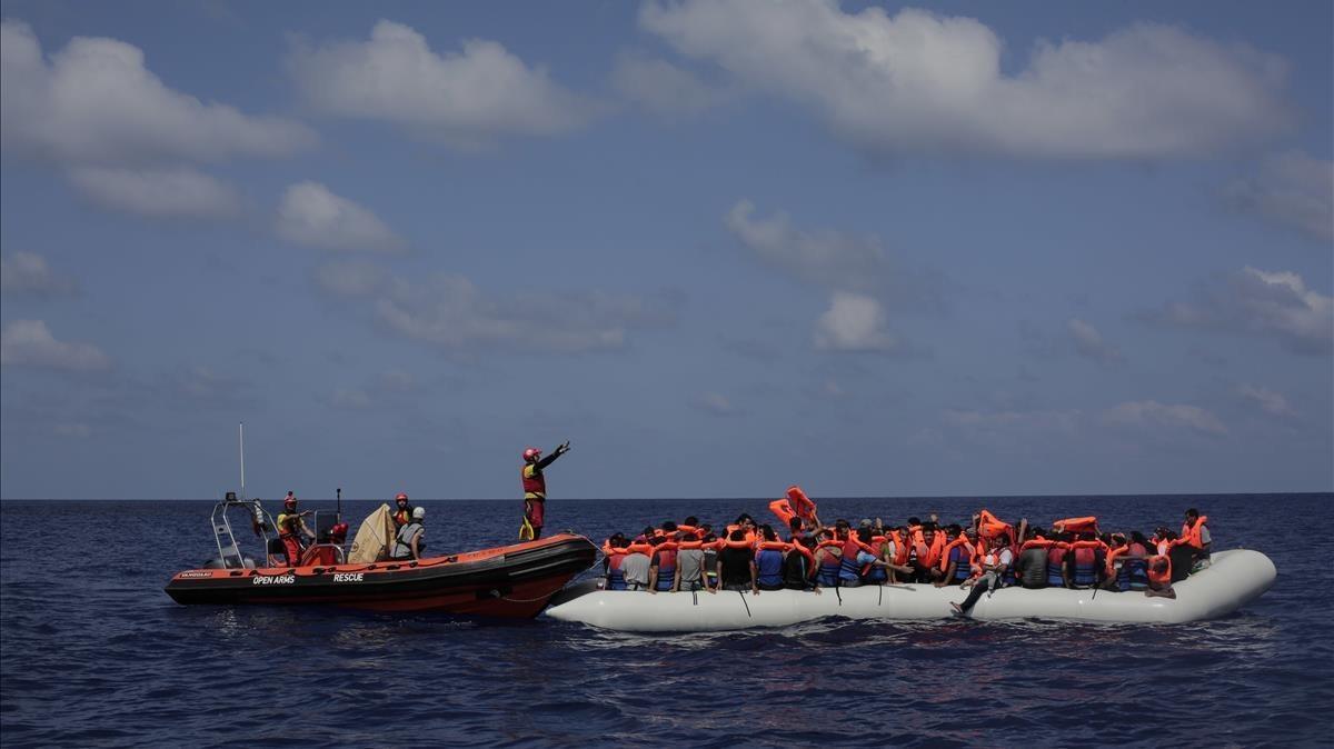 Inmigrantes esperan a ser rescatados en su atestado bote neumático por integrantes de Proactiva Open Arms, frente a las costas de Libia, el 6 de septiembre.