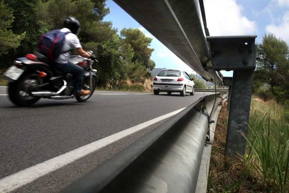 Una moto circula por la sinuosa carretera entre Tossa de Mar y Lloret. Una moto circula por la sinuosa carretera entre Tossa de Mar y Lloret.