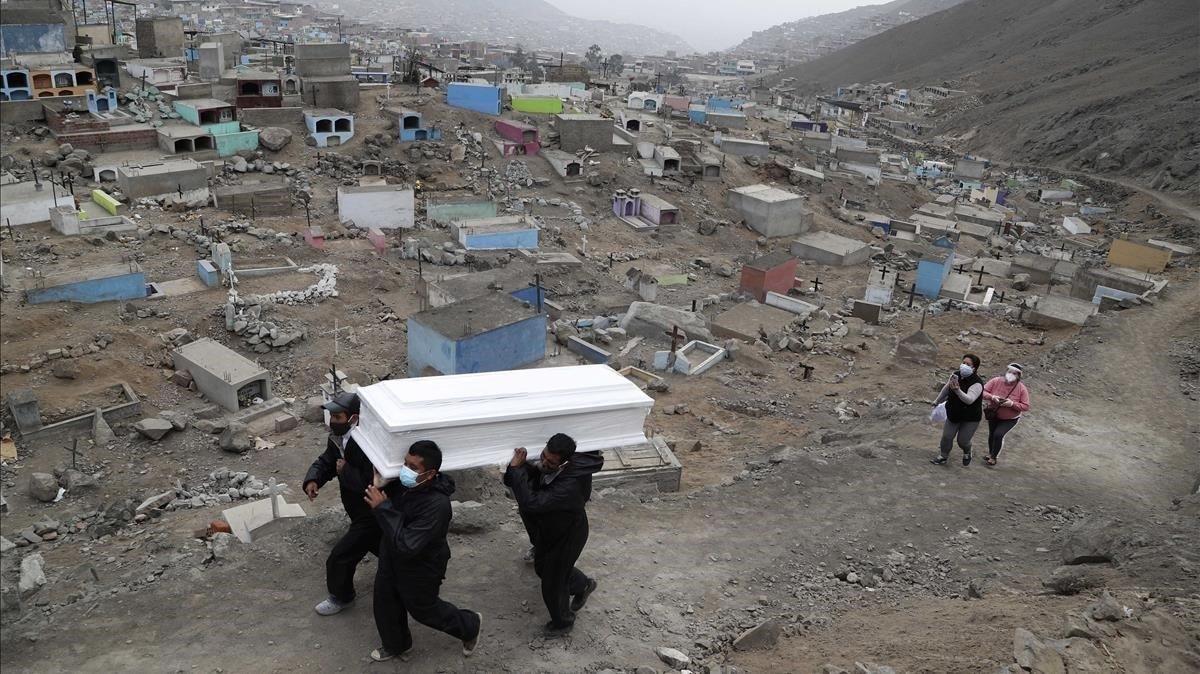 Trabajadores de un cementerio de Lima portan el féretro de un fallecido por covid, el miércoles pasado. Trabajadores de un cementerio de Lima portan el féretro de un fallecido por covid, el miércoles pasado.