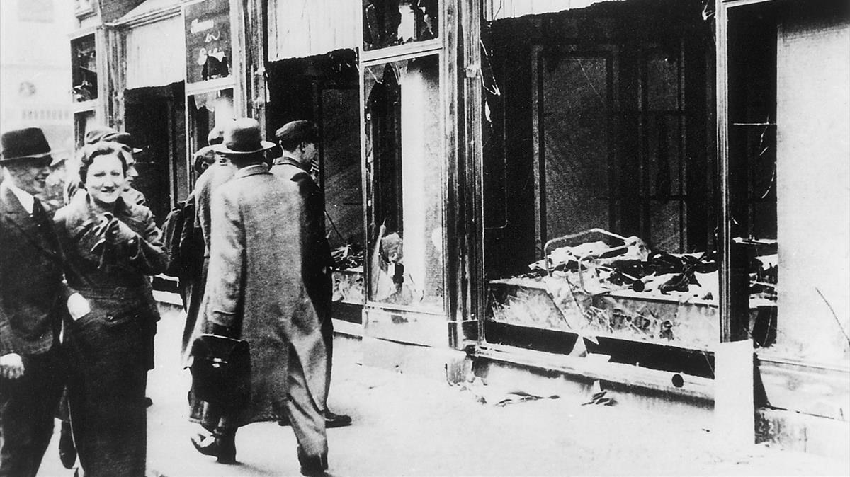 Transeúntes indiferentes ante una tienda judía destruida y saqueada en la Alemania nazi. 