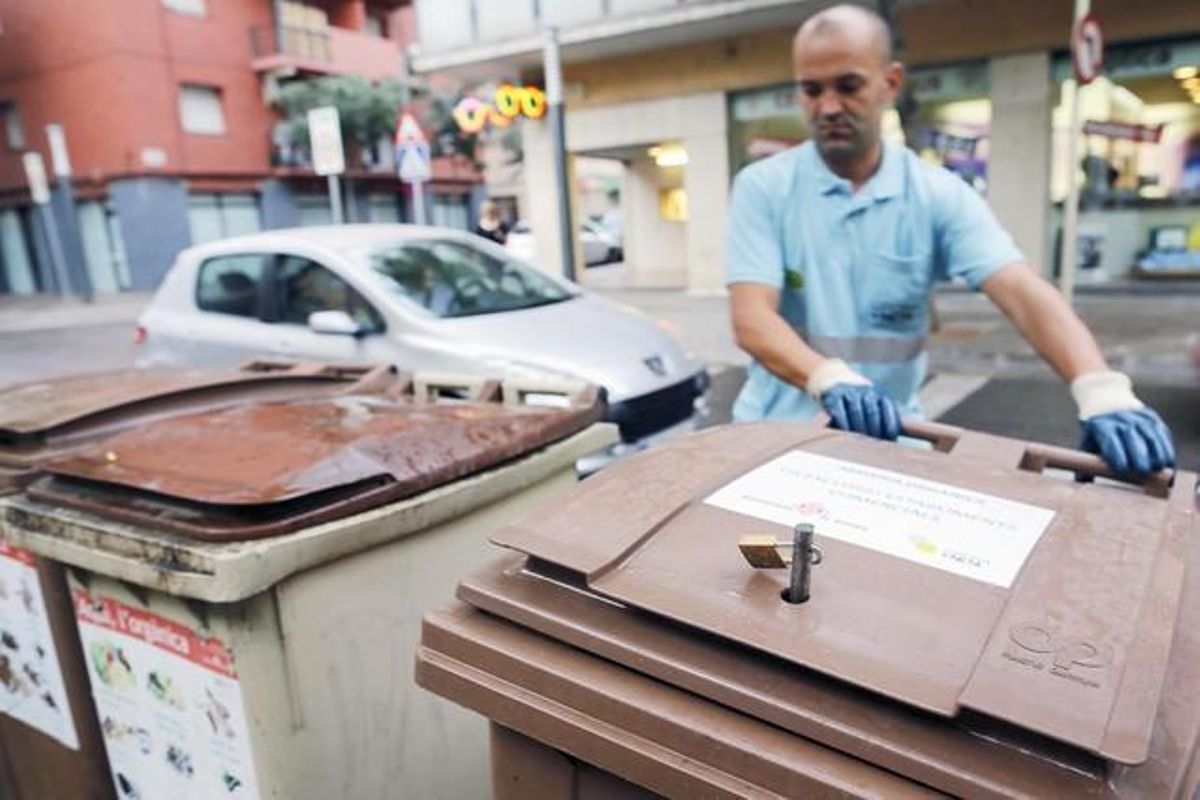 Un operario instala los nuevos contenedores con candado para supermercados, el lunes, en Girona. Un operario instala los nuevos contenedores con candado para supermercados, el lunes, en Girona.