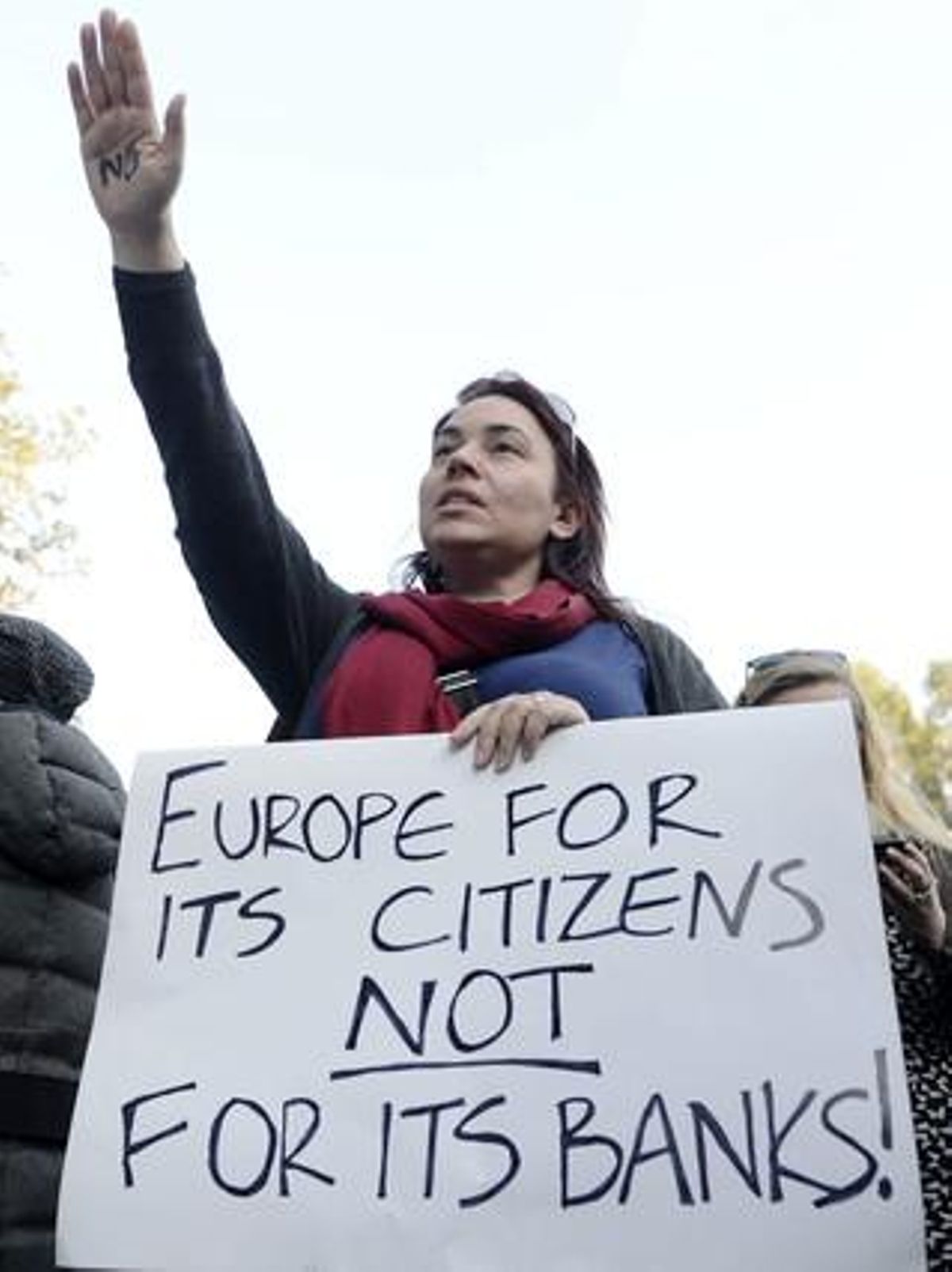 Una mujer protesta en Nicosia, este lunes, contra las medidas del Eurogrupo con un cartel en el que se lee Europa es de sus ciudadanos, no de sus bancos. Una mujer protesta en Nicosia, este lunes, contra las medidas del Eurogrupo con un cartel en el que se lee Europa es de sus ciudadanos, no de sus bancos.