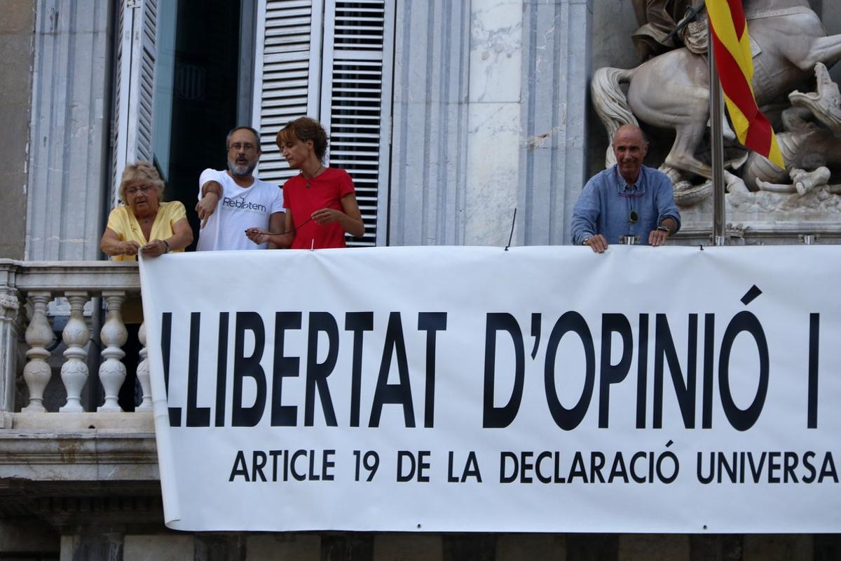 Lluís Llach, Sílvia Bel, Antoni Baños y Teresa Casals colocando la pancarta en la Generalitat. 