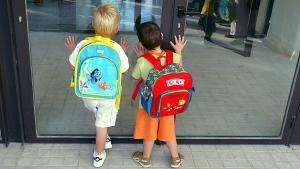 Dos niños esperan a que abran las puertas en su primer de clase de educación infantil, en el 2003.