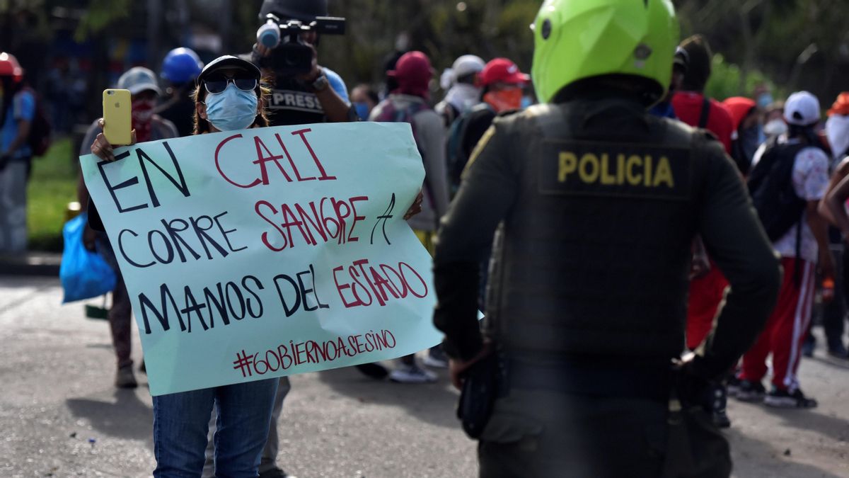 Un manifestante sostiene un cartel durante una protesa en Cali, el 11 de mayo. Un manifestante sostiene un cartel durante una protesa en Cali, el 11 de mayo.