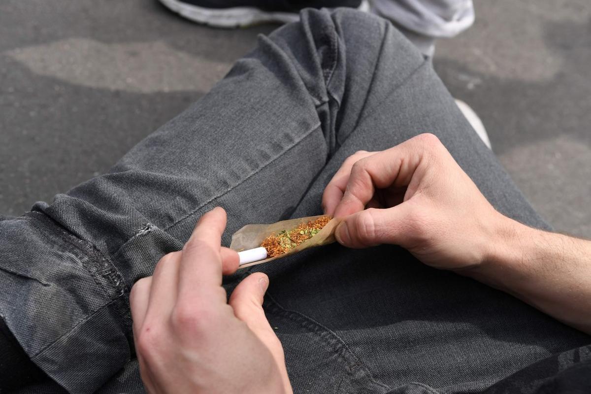 Una persona lía un cigarrillo de cannabis.