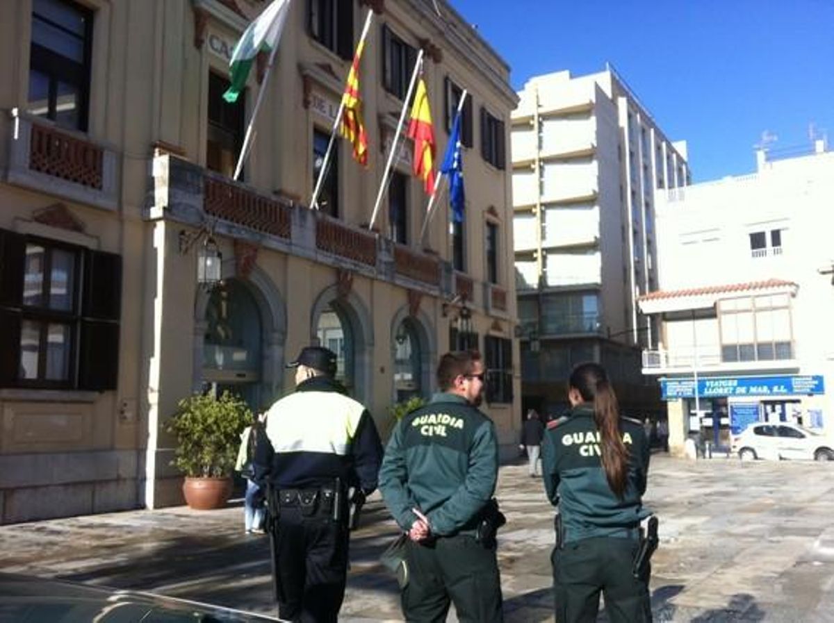Un policía municipal y dos guardias civiles, frente al Ayuntamiento de Lloret, este viernes. Un policía municipal y dos guardias civiles, frente al Ayuntamiento de Lloret, este viernes.