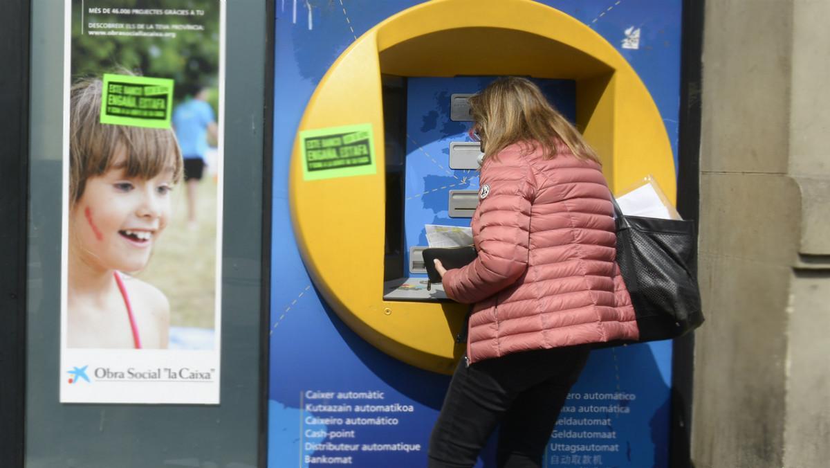 Una mujer saca dinero del cajero automático. 