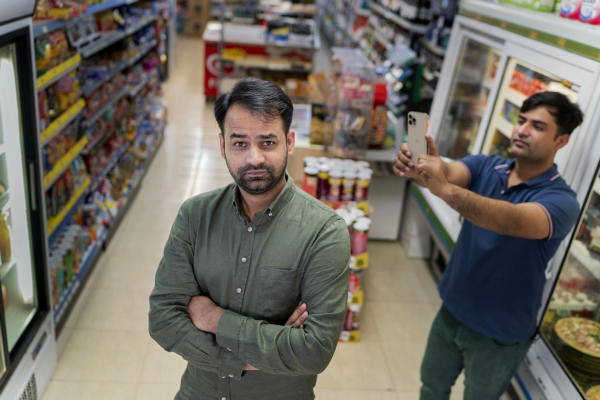Rustem Iqbal posa en el Súper Pim Pam, en la calle Girona, junto a su hermano Qasim, su cámara de TikTok. Rustem Iqbal posa en el Súper Pim Pam, en la calle Girona, junto a su hermano Qasim, su cámara de TikTok.