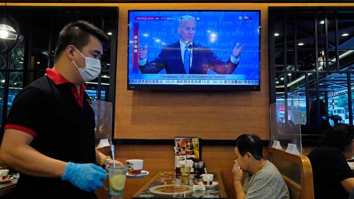 Biden ve criminal la separación de familias migrantes y Trump la defiende. En la foto, seguimiento del debate en un bar de Hong Kong.