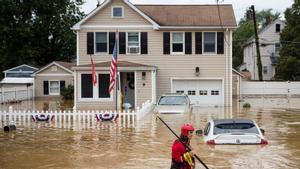 Un voluntario atraviesa las aguas anegadas en la localidad de Helmetta, en el estado estadounidense de Nueva Jersey, este domingo.